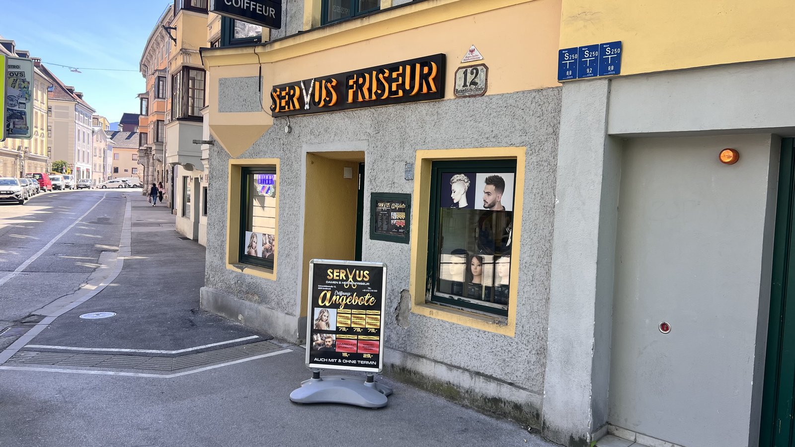 Eingang Servus Friseur mit Angebote-Aufsteller