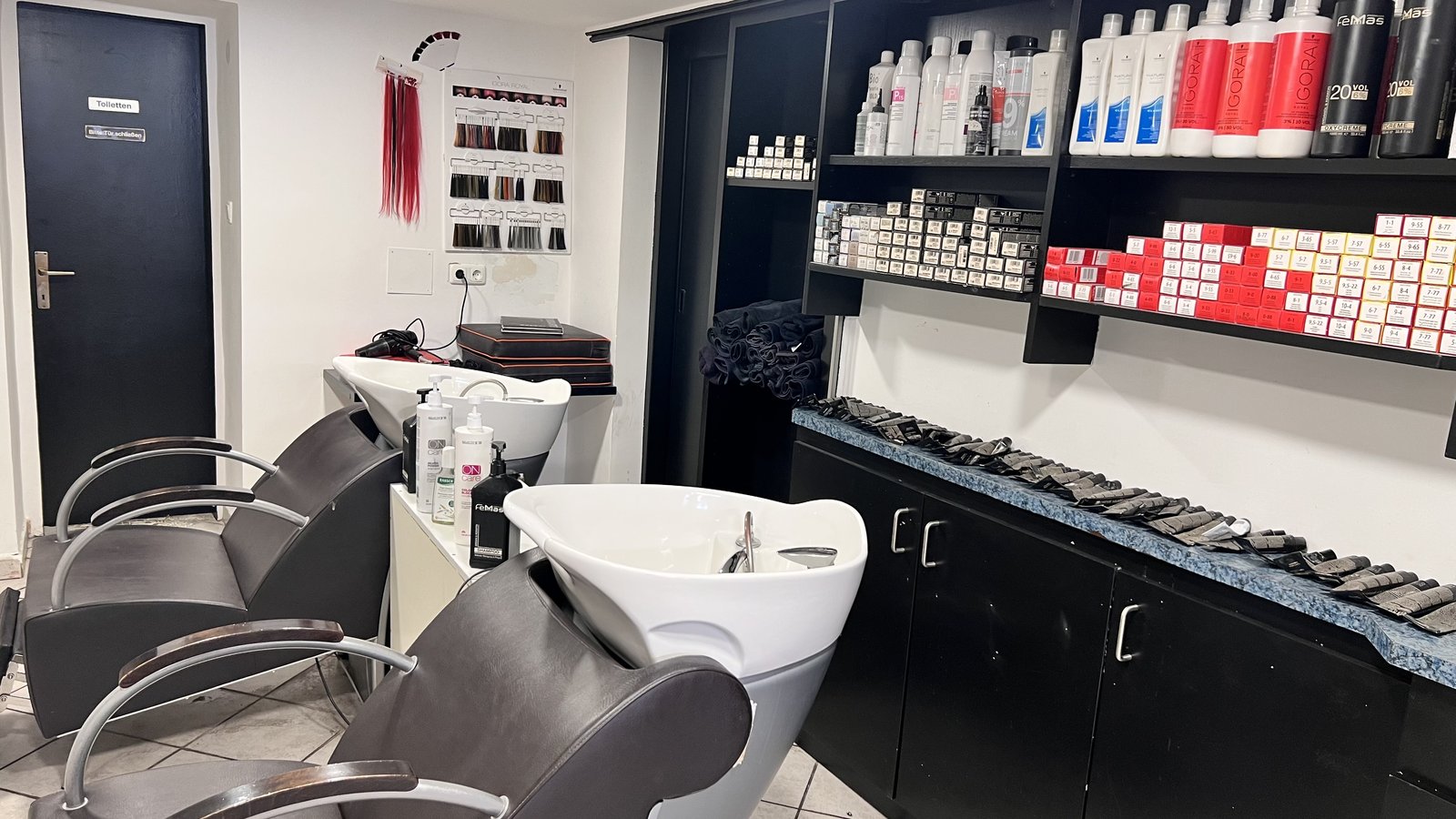 Waschbereich mit schwarzen Friseurstühlen